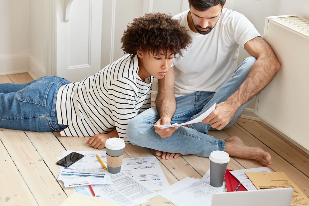 Couple reviewing bills and finances at home with coffee.